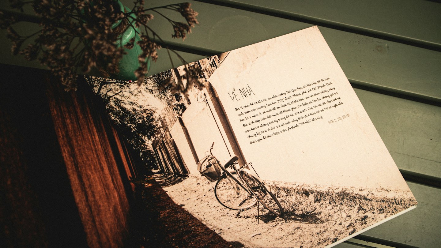 An open book displays a bicycle photo and text on wood.