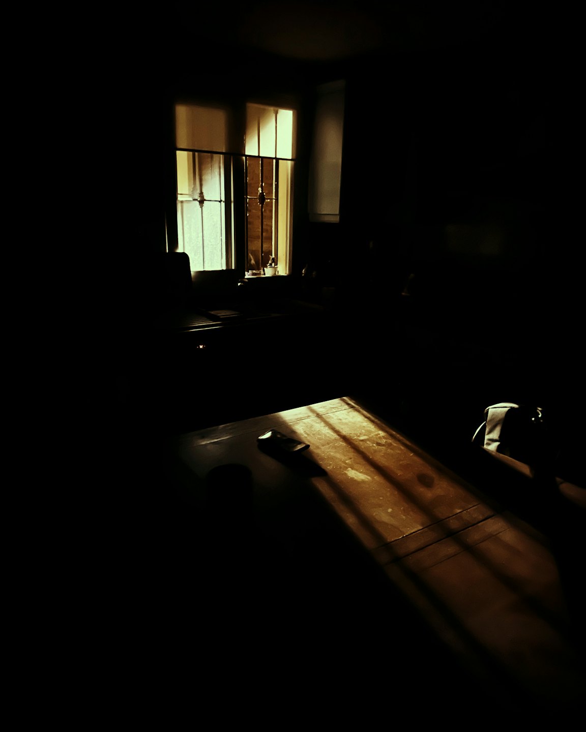 Sunlight streams through an old window onto a wooden table.